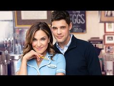 a man and woman standing next to each other in front of a coffee shop counter