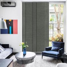 a living room filled with furniture and a window covered in shades of blue, red, yellow and white