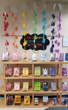 there is a book shelf with many books on it and some decorations hanging from the ceiling