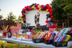 a table topped with lots of food and balloons