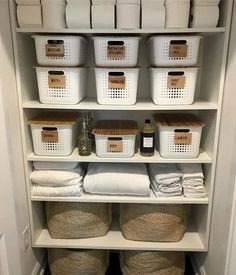 an organized pantry with baskets and towels