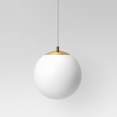 a white and gold ball hanging from a ceiling light with a black cord in front of it