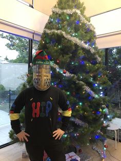 a man in a hockey mask standing next to a christmas tree