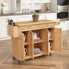 a kitchen island with plates and cups on it in the middle of a wooden floor