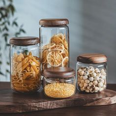 three glass jars filled with food on top of a wooden table