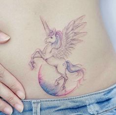 a woman's stomach with a tattoo of a unicorn and a bird on it