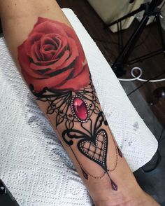 a rose on the arm with a heart and a cage around it that is decorated with jewels