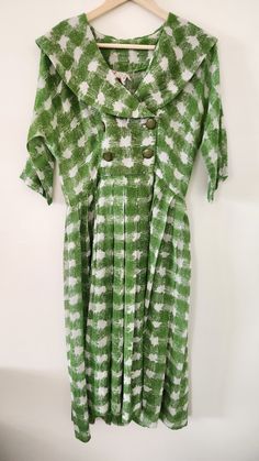 "Look at this charming, cheerful spring-ready day dress by Spector and Shanler of New York. The fabric is a lovely green print in a very lightweight - almost gauze, with a deep shawl collar and two rows of buttons. Color is maybe a little more olive than it appears in pics. Fit and flare, looks like it used to have a belt, but that has gone missing sometime in the last 60-70 years, unfortunately. It's in remarkable shape otherwise, though. The hem is very deep, which gives it a bit of weight and swingy-ness.  Tag Sizing: None Measurements: Armpit to armpit: 17.5\" Shoulder to shoulder: 17\" Sleeve: 13.5\" Back from base of collar: 16.5\" to waist Skirt: 26\" How we measure: with garment laid flat, we measure straight across at the listed areas. Size conventions differ with era, so please t Casual Green Knee-length Vintage Dress, Fitted Green Vintage Dress For Spring, Green Short Sleeve Vintage Dress For Spring, Green Summer Vintage Dress For Garden Party, Green Vintage Knee-length Dress For Spring, Green Retro Vintage Dress With Short Sleeves, Green Knee-length Vintage Dress For Spring, Green Knee-length Vintage Dress, Vintage Green Spring Dresses