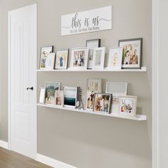 there are many pictures on the wall above the shelves in this room, and one is displaying family photos