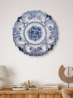 a blue and white plate sitting on top of a wooden table next to a lamp