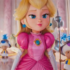 a close up of a doll wearing a pink dress with blue eyes and blonde hair