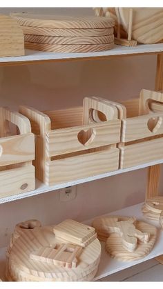 several wooden baskets and bowls on shelves in a room with white shelving, one is made out of plywood