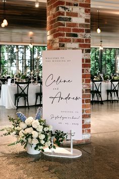 a sign that is sitting on the ground in front of a table with flowers and candles