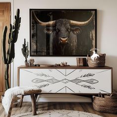 a cow's head is mounted on the wall above a dresser