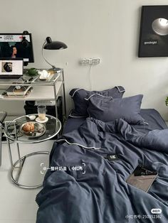 a bed sitting in a bedroom next to a desk with a computer on top of it