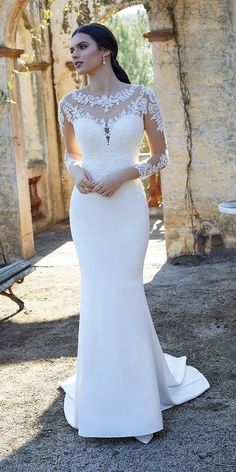 a woman in a wedding dress standing outside