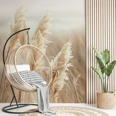 a chair and rug in front of a wall with grass on it, next to a potted plant