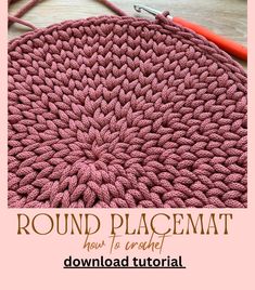 the round placemat is crocheted in pink yarn and sits on top of a table