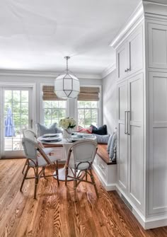 a dining room with white walls and wood floors