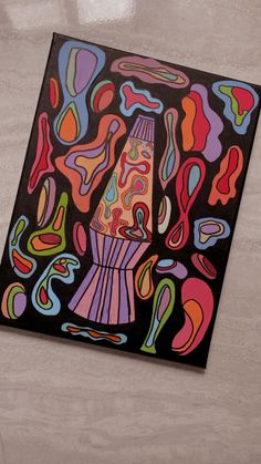 a painting on the wall with an abstract design in black, pink, orange and green