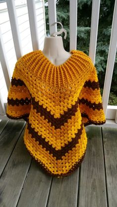 a crocheted sweater is sitting on the porch