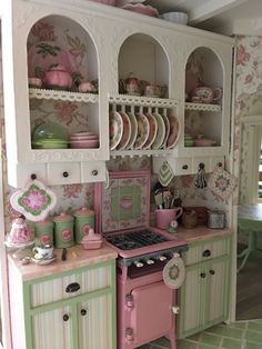 a doll house kitchen with pink and green accessories