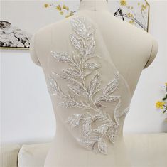 the back of a white dress with silver sequins on it