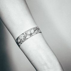 a black and white photo of a woman's wrist with a flower tattoo on it