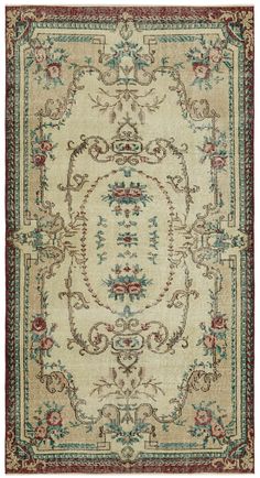 an antique rug with floral designs on the center and border in red, blue, green and beige colors