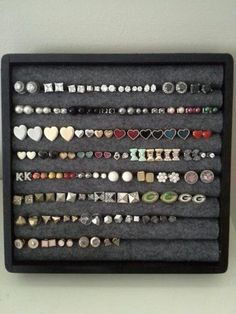 a display case with many different types of buttons and charms on the inside of it