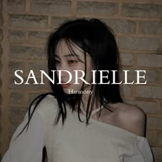 a woman standing in front of a brick wall with the words sandhrielle on it