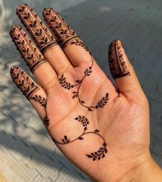 a woman's hand with henna tattoos on it