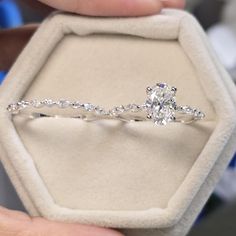 a person holding an engagement ring in a box with diamonds on the inside and outside