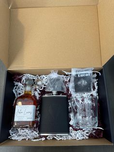 an open box containing two flasks and liquor