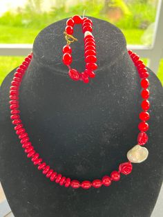 This red glass bead set is a stunner with matching bracelet. Both have gold toggle clasp's. Necklace and bracelet are both accentuated with a beautiful potato pearl. Surrounding the pearl on the necklace are red rose beads that are just adorable. Perfect gift for Valentine's Day, Mother's Day. Sure to be a winner! Elegant Red Hand-strung Jewelry, Red Pearl Jewelry With Polished Beads, Elegant Red Faceted Bead Pearl Necklace, Elegant Red Pearl Necklace With Faceted Beads, Red Round Pearl Jewelry, Classic Red Beaded Jewelry, Classic Red Hand-strung Jewelry, Pearl Necklace Set, Toggle Clasp