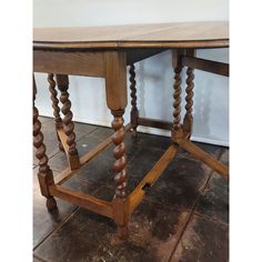 an old wooden table with spiral legs