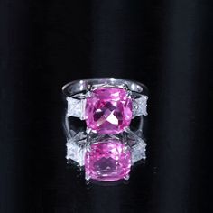 a pink diamond ring sitting on top of a table