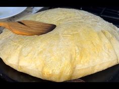 a wooden spoon sitting on top of a piece of bread in a black skillet