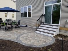 an outdoor patio with steps, table and umbrella