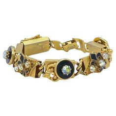 This is a 1960s Kramer of NY bracelet with Fleur de Lis. It has six linked detailed 3D design gold tone metal block sections and a fold-over clasp. Alternating sections are decorated with fleur di lis and round black enamel button shape with prong set AB rhinstones on top. Kramer of NY, a well-respected name and collected costume jewelry line. Louis Kramer founded the company in 1943. Our vintage jewelry collection and original creations are all unique listings. We never have multiple copies of anything. So, if you miss the current opportunity you may not get another chance to own the piece you love. It usually takes us one day to ship out orders excepting weekends. We have 20 years of online business and shipping experience. We have quite different inventory for our physical store and onl Rose Gold Fashion, Gold Link Bracelet, Rhinestone Bracelet, Pink Bracelet, Vintage Bracelets, Clear Rhinestones, Black Enamel, Gold Tone Metal, 3d Design