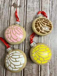 three ornaments are sitting on a wooden surface