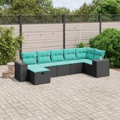 an outdoor sectional sofa with blue cushions on a brick patio area next to a fence and shrubbery