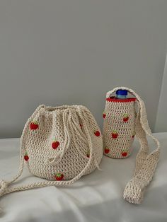 two crocheted bags with strawberries on them sitting on a white surface next to each other