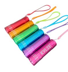 four different colors of water bottles with lanyards attached to each one on a white background