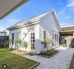 a small white house sitting in the middle of a yard