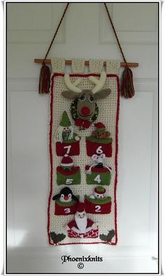 a knitted christmas stocking hanging on a door hanger with numbers and animals