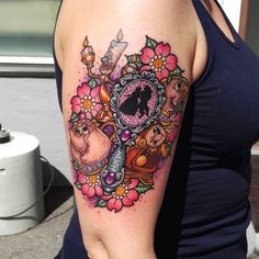 a woman with a clock and flowers tattoo on her arm