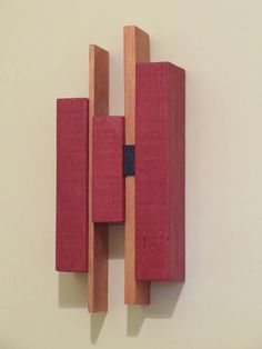 a red piece of wood mounted to the side of a wall next to a white wall