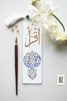 a pen and some flowers on a white surface with the words written in two different languages