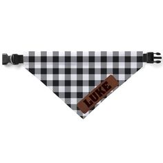 a black and white checkered dog bandana with the word luke written on it